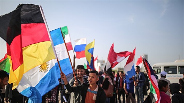 Toprak Günü'nün 42'nci yılı kapsamında barışçıl eylemlerine devam eden Filistinliler, Gazze Şeridi'nin doğu sınırında ellerinde taşıdıkları dünya ülkelerine ait bayraklarla renkli görüntüler oluşturdu.