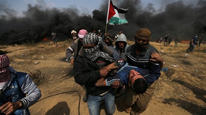A wounded demonstrator is evacuated during clashes with Israeli troops at a protest where Palestinians demand the right to return to their homeland, at the Israel-Gaza border in the southern Gaza Strip, April 27, 2018.