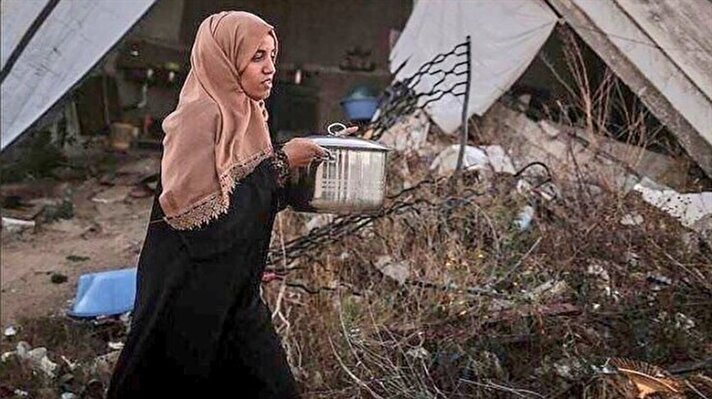 Bombardıman sonucunda yıkılan evinin kalıntıları arasında kitaplarını arayıp bulan küçük kız. 