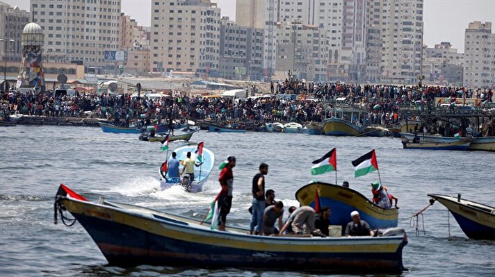 People gather as Palestinians prepare to sail a boat towards Europe aiming to break Israel's blockade on Gaza, at the sea in Gaza May 29, 2018. 