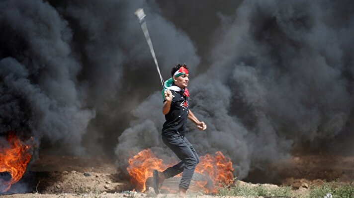 A Palestinian demonstrator reacts to tear gas fired by Israeli troops during a protest marking al-Quds Day, (Jerusalem Day), at the Israel-Gaza border, east of Gaza City June 8, 2018. 