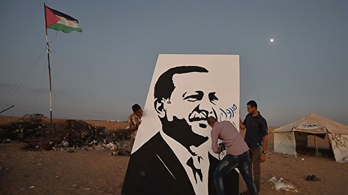 Palestinian artist Bahaa al Haribi draws the portrait of Turkish President Recep Tayyip Erdogan to celebrate his presidential election success near Israel-Gaza border in Khan Yunis, Gaza on June 25, 2018

