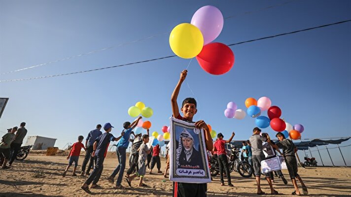 Gazzeli çocuklar, Hamas'ın kurucularından Şeyh Ahmed Yasin ve eski Filistin Devlet Başkanı Yasir Arafat gibi Filistin direnişinin sembol isimlerinin fotoğraflarını taşıyan rengarenk balonları gökyüzüne saldı.
