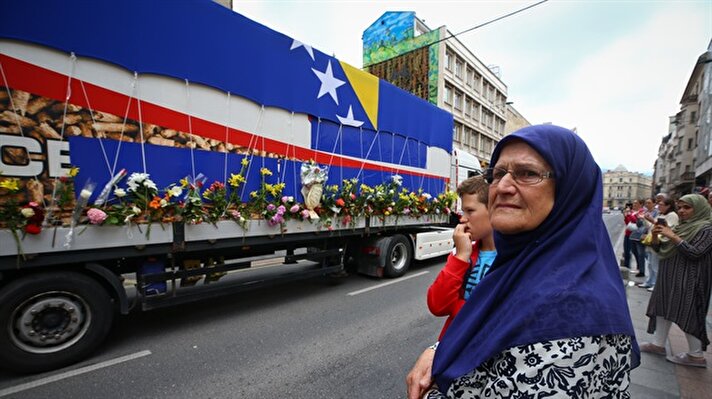 The remains of 35 Srebrenica genocide victims were placed on a truck laden with flowers in the Bosnian city of Visoko on Monday morning for their final journey to a cemetery.​