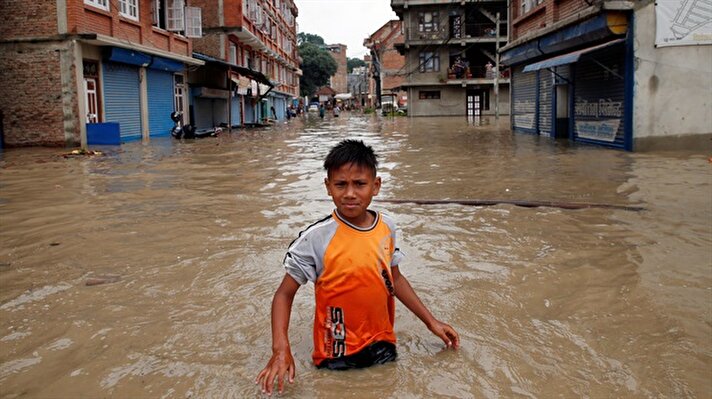 A boy walks along the flooded neighborhood after incessant rainfall in Bhaktapur, Nepal July 12, 2018.