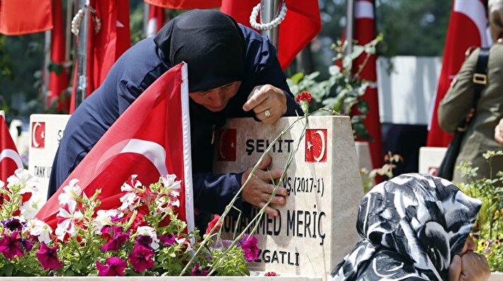 Relatives of the martyrs mourn near graves during the July 15 Democracy and National Unity Day to mark July 15 defeated coup's 2nd anniversary at Karşıyaka Cemetery in Ankara, Turkey on July 15, 2018. 249 people were martyred and nearly 2,200 people injured in the defeated 15th of July 2016 coup attempt, which was carried out by the Fetullah Terrorist Organization (FETÖ) led by U.S.-based terror ringleader Fetullah Gulen.​