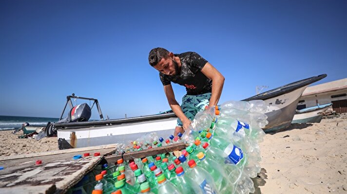 Filistinli balıkçı Muaz Ebu Zayd, maddi imkansızlıklar nedeniyle sokaktan topladığı yaklaşık 700 pet şişe kullanarak kayık yaptı. 