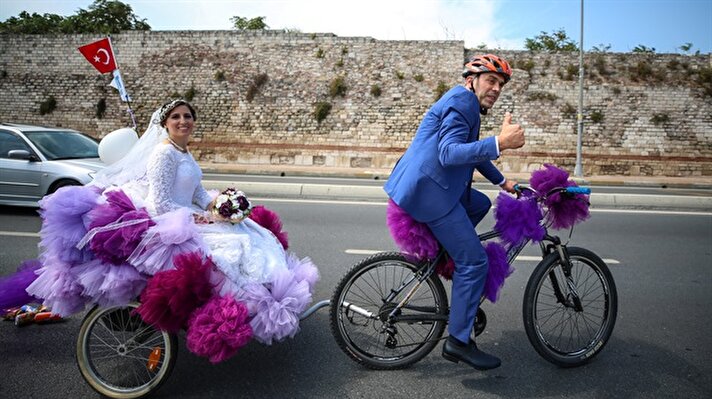 Bridal couple are seen on a wedding convoy at Sarayburnu coast riding a wedding vehicle made by a bicycle in Istanbul, Turkey on September 09, 2018.

