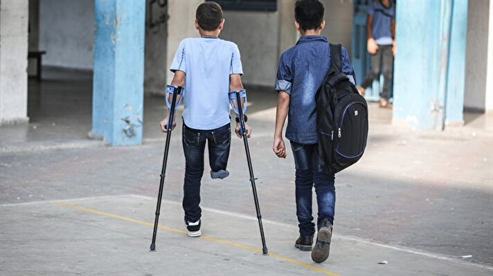 Gazze sınırında geçen haziran ayında düzenlenen gösterilerde İsrail kurşunlarına hedef olan ve sağ bacağını kaybeden Muhammed, geçen dönem arkadaşlarıyla top oynadığı okul bahçesinde, aylar sonra ancak oyun oynayan arkadaşlarını izleyebiliyor.   