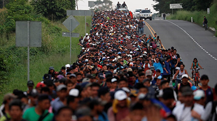 Migrants, part of a caravan traveling from Central America en route to the United States walk by the road that links Ciudad Hidalgo with Tapachula