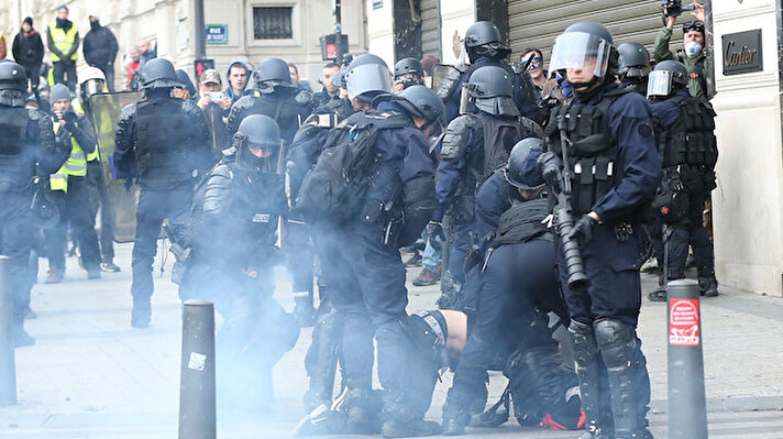 French police intervene in yellow vests' (gilets jaunes) protest against rising oil prices and deteriorating economic conditions along the Champs-Elysees Avenue in Paris, France on December 08, 2018. French police used pepper spray against protesters.

