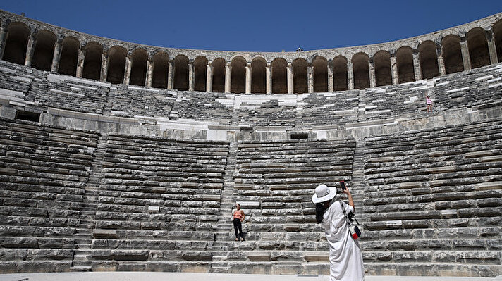 Tourists take photos at antique theatre of Aspendos, built by the Romans in 160-180 A.D, in Serik district of Antalya, Turkey on August 6, 2019. Aspendos, which is among the examples of the best designed Roman theaters, is one of the best-preserved ancient amphitheater and is still used for concerts and festivals.
