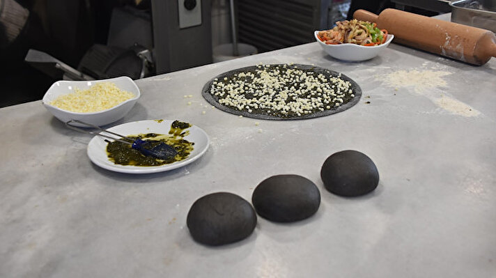 Karşıyaka'da bulunan bir işletmede kafa kafaya veren şefler, deniz ürünlerinin kullanıldığı 'siyah hamurlu pizza' üretmeye karar verdi. Yapılan denemelerin ardından siyah pizza menüye konulurken, müşteriler renginden dolayı büyük bir şaşkınlık yaşadı.