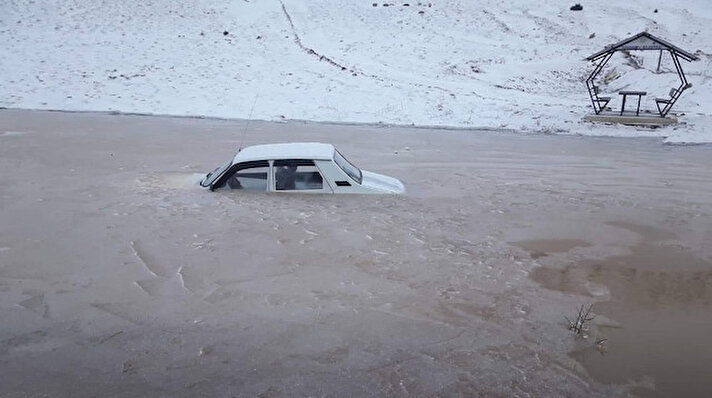 Buzlanmadan dolayı kayıp yol kenarındaki su birikintisine düşen otomobil buz tuttuğu için çıkartılamadı.