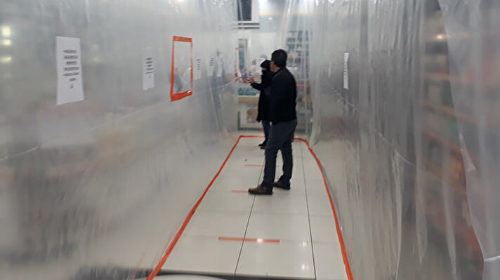 Başakşehir'de iki eczane içeriye giren müşteri ile çalışanların temasını kesmek ve virüsün bulaşmasını önlemek amaçlı seffaf brandalar koydu.