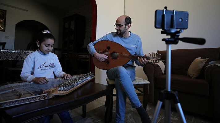 Gazze'de yeni tip koronavirüs (Kovid-19) salgını nedeniyle evinde kalan Filistinli müzik öğretmeni Muhammed El-Habbaş, 8 yaşındaki kızı Rima ve öğrencilerine sosyal medya üzerinden müzik dersi veriyor.