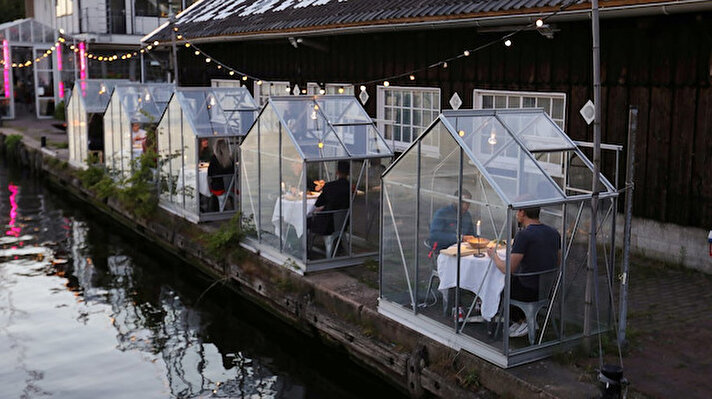 Hollandalı bir restoran, corona virüsü salgını döneminde müşterilerine hizmet etmek için yeni bir konsept geliştirdi. Reuters’ta yer alan habere göre, Mediamatic Sanat Merkezi'nin restoranı, müşteriler için kozayı andıran 2-3 kişilik camdan küçük kabinler yaptı.