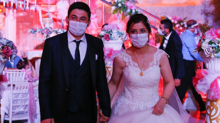 Bride Pelsin Akkoyun and groom Nizamettin Bingol, wearing protective face masks, walk following their civil wedding ceremony, amid the spread of the coronavirus disease (COVID-19), in Diyarbakir, Turkey, July 2, 2020. Turkey reopened its wedding halls in one of the final steps of reopening from the shutdown due to the coronavirus disease (COVID-19). REUTERSSertac Kayar  