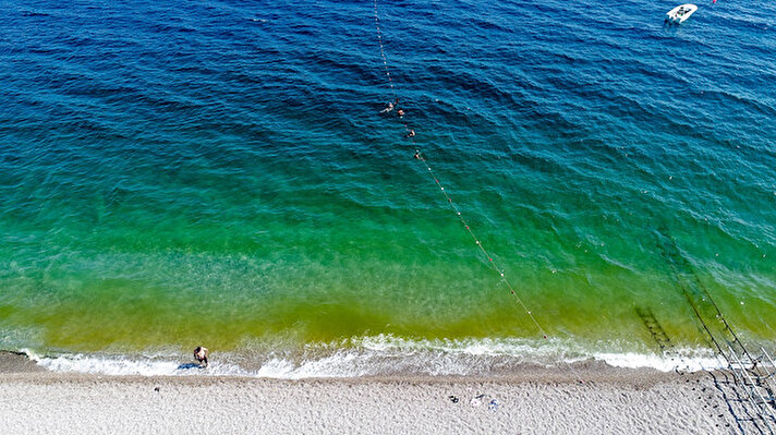 Antalya'nın dünyaca ünlü Konyaaltı Sahili’nde deniz suyu, öğle saatlerinden itibaren yeşil renge döndü. Sahilde denize girip güneşlenen tatilciler yeşil renkli suyu görünce korkuya kapıldı.