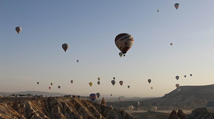 Türkiye'nin önemli turizm merkezlerinden Kapadokya bölgesinde bu sabahın ilk ışıklarıyla birlikte havalanan sıcak hava balonları gökyüzünde görsel şölen yaşatırken, objektiflere kartpostallık görüntüler yansıdı.