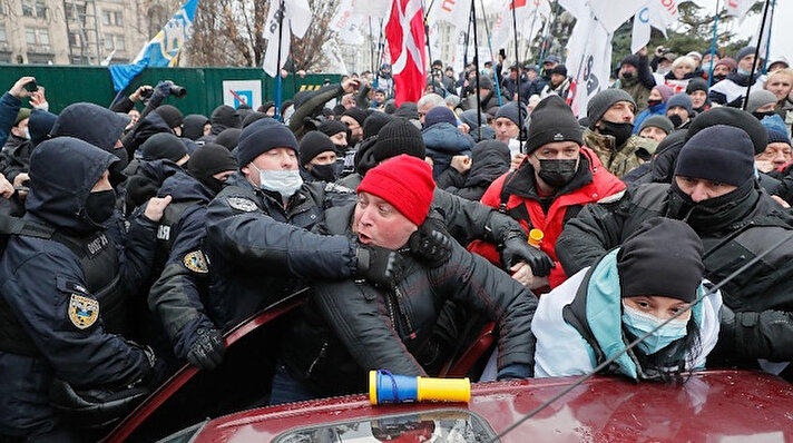 Geçtiğimiz haftalarda Başkent Kiev’de, Covid-19 ile mücadele kapsamında uygulanmak istenen yeni karantina kuralları ve şirketlerin yazar kasa kullanımına geçiş zorunluluğu getiren yasaya karşı çıkan yüzlerce kişi sokağa dökülmüştü. Hükümet tarafından alınan bu kararlar Ukrayna Meclis binasının önünde de protesto edilmişti. Protestolar 15’inci gününde devam ederken, Kiev’de polis ile göstericiler arasında tansiyon yükseldi. Başkentteki Hırşatik Meydanı’nda çadır kurmak isteyen göstericiler ve polis arasında arbede yaşandı. Ukrayna Polis Teşkilatı tarafından yapılan açıklamada, çıkan olaylarda 40 polisin yaralandığını duyurdu.