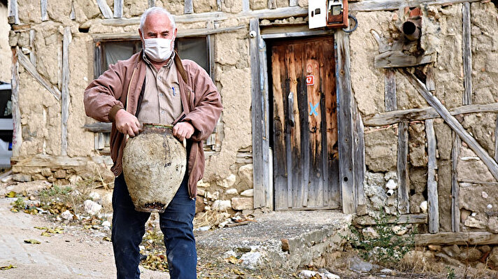 Koyunlu köyünde iki katlı evi aile büyükleriyle gezen 65 yaşındaki Ateş, binanın yan girişinde bulunan merdivenin altında, toprağa gömülmüş ve üst kısmı açığa çıkmış bir küp gördü.
