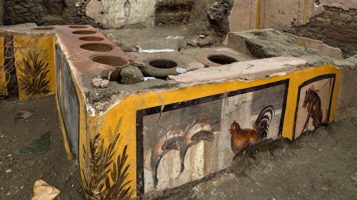 Parlak renkli freskler. Delikli bir tezgah. Görüntülerin adresi İtalya'daki Pompeii Antik Kenti.
