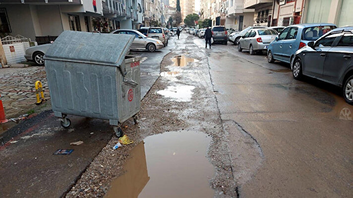 Fahrettin Altay Mahallesi 65/20 Sokak'ta yaklaşık 1 ay önce yapılan kanalizasyon çalışmasında kazılan sokaklar, iş bitiminde tam olarak kapatılmayınca yolda çukurlar ve asfaltta derin yarıklar oluştu.