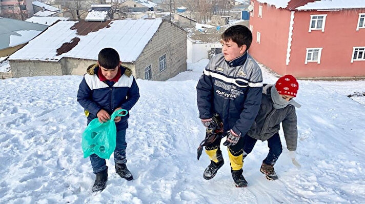 Mahallelerinde bulunan bir tepeyi kendileri için kayak merkezi haline getiren çocuklar, kızakları olmadığı için evlerinden getirdikleri poşetler üzerinde saatlerce kayak yapmanın keyfini çıkardı.