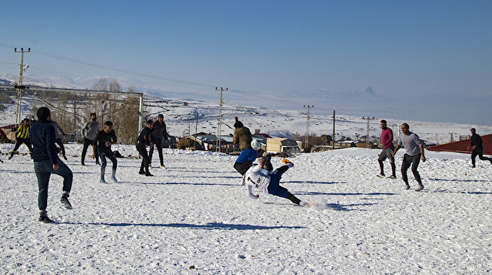 Iğdır'da kardan zaman zaman yolu kapanan dağ köylerinde yaşayan vatandaşlar, zorlu kış koşullarını, kar üzerinde futbol turnuvası düzenleyerek eğlenceye dönüştürüyor.