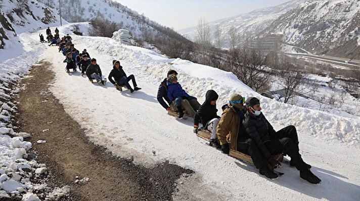 Ilıcalar beldesine bağlı Elmalı köyünde karın kapattığı köy yolunu kayak pistine dönüştüren çocuklar kızakla kayarak doyasıya eğlendi.