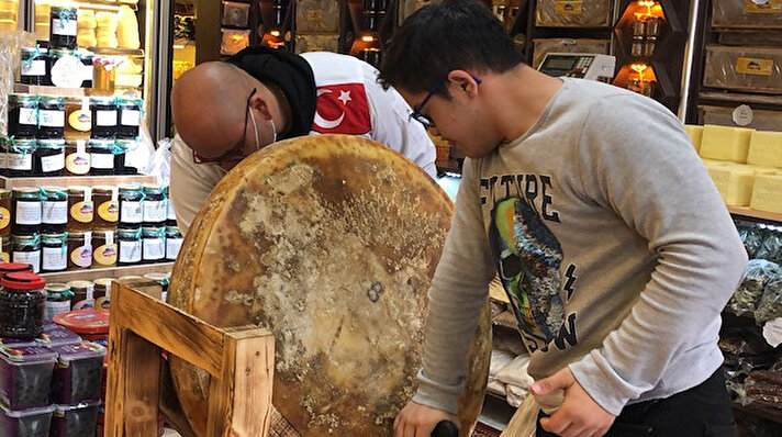 Atatürk Caddesi'ndeki iş yerinde dev Gravyer peynirini satışa sunan Mahmut Bilgir, pyniridown sendromlu oğlu Muhammet Efe Bilgir (15) ile birlikte kesti.