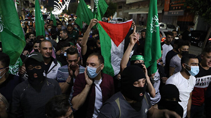 
Filistin bayrakları taşıyan binlerce kişi, Gazze Şeridi'nin İsrail işgaline karşı direniş sloganları attı. Şehir merkezindeki Al-Shuhada Caddesi kontrol noktasına ulaşan protestocular, lastik tekerlekleri ateşe vererek İsrail askerlerine taş ve havai fişek atarak karşılık verdi. 