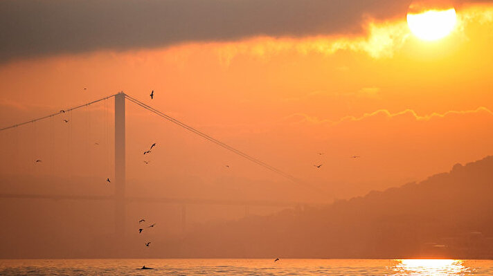 İstanbul`da avlanmaya çıkan balıkçılar, 15 Temmuz Şehitler Köprüsü ile gün doğumunda oluşan manzaranın güzelliğine güzellik kattı.