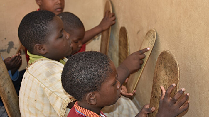 Başkent Nuakşot'taki Sıddık Medresesi'nde 5-15 yaş arasındaki 250 çocuk, tahta levhalar üzerine yazılan ayetleri ezberlemeye çalışıyor.
