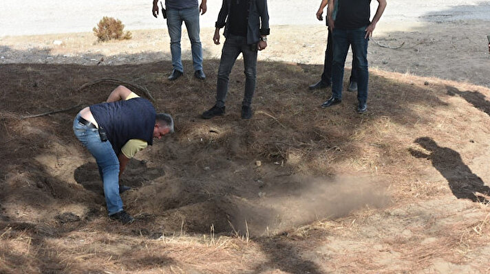 Muratpaşa ilçesi Güzeloba Mahallesi Lara kumluk ve ormanlık alanda gezintiye çıkan vatandaşlar bir çam ağacı altındaki mezar şeklindeki tümseği 112 Acil Çağrı Merkezine bildirdi.