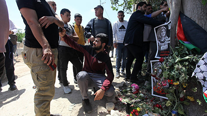 Ebu Akile'nin öldürüldüğü yeri ziyaret etmek için sabahın erken saatlerinden itibaren farklı yerlerden akın eden Filistinliler, olayın gerçekleştiği yerde gözyaşları dökerek çiçek bıraktı.