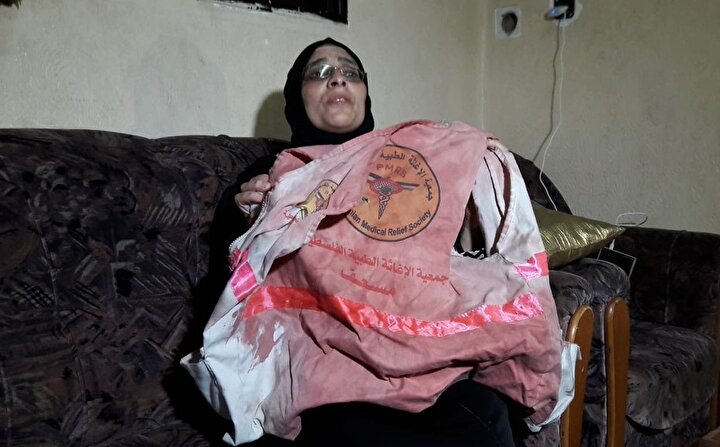 Razan'ın, ''Kıymetli insanların kanıyla boyandı'' dediği üniforması, kendi kanıyla boyanmış bir halde, annesinin ellerinde.