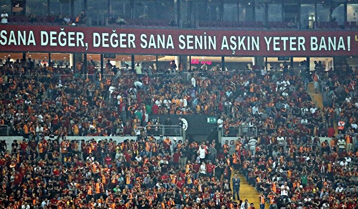 Tribünleri dolduran sarı kırmızılı taraftarlar hazırladıkları pankartlarla oyuncuları motive ediyorlar.