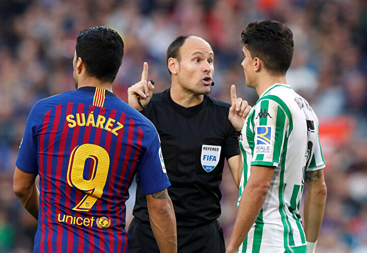 Antonio Mateu Lahoz, oyuncuları sert bir şekilde uyarırken...