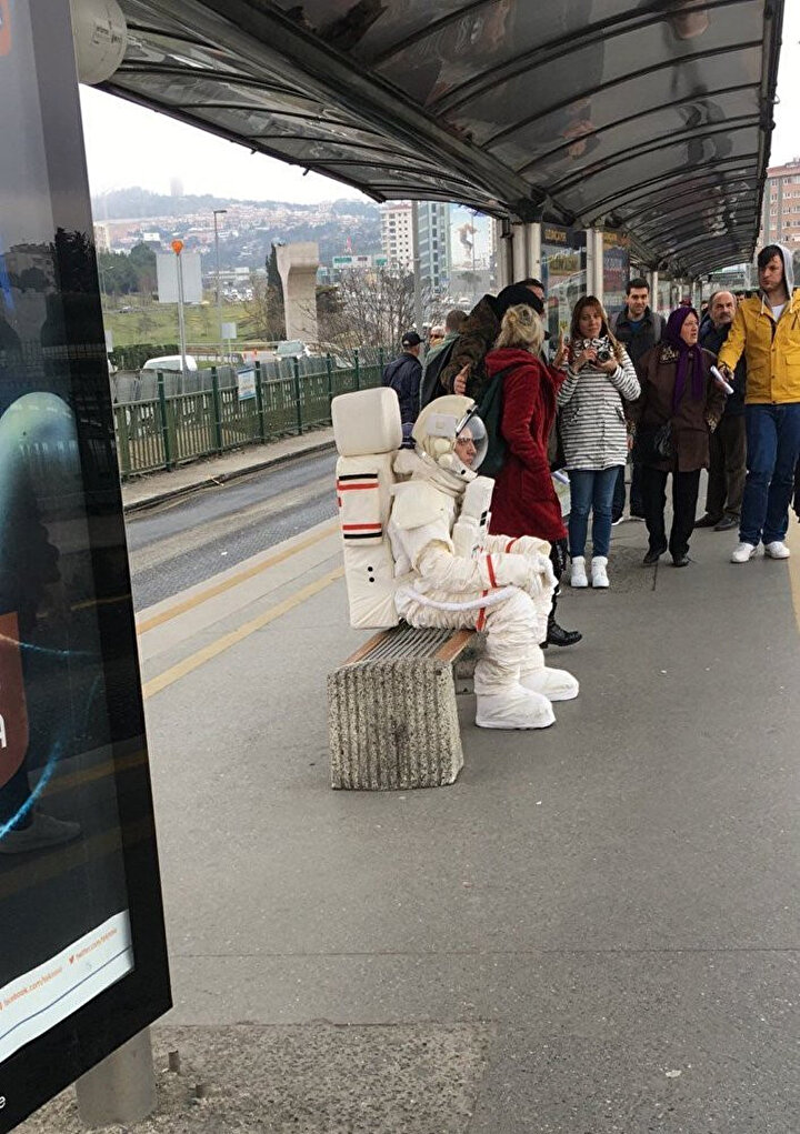 O an durakta oturan çoğu yolcunun dikkatini çekmeyi başaran astronotu görenler, telefonlarına sarılarak o anı ölümsüzleştirmek istedi.