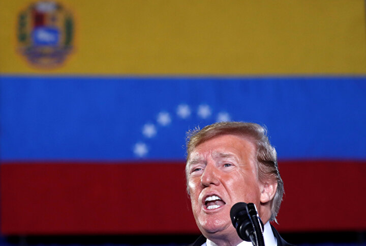 Donald Trump,Venezuela bayrağının önünde konuşma yapıyor.