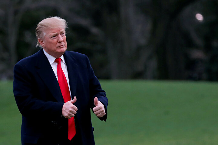 ABD Başkanı Donald Trump kameralara poz veriyor.