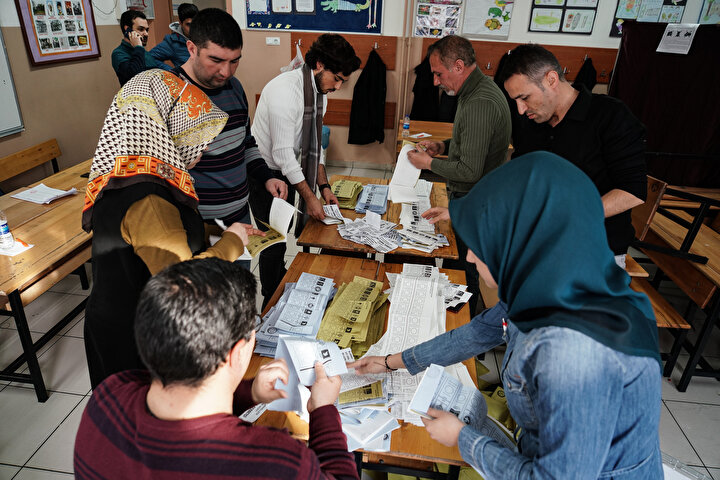 Sandık görevlileri oy sayımı sırasında görülüyor.