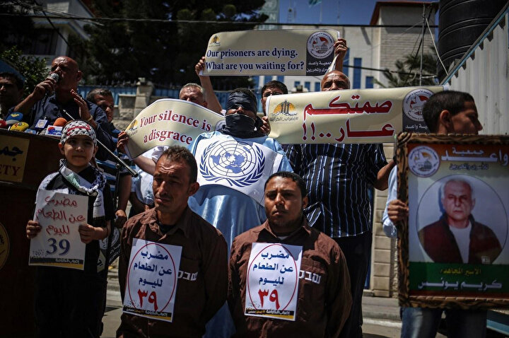 Açlık grevine katılan Filistinli tutuklulara destek olan protestocular, üzerinde ''Filistinli tutuklular ölüyor. Siz neyi bekliyorsunuz?'', ''Sessiz kalmanız rezalet'' gibi ifadeler içeren pankartlar tuttu.