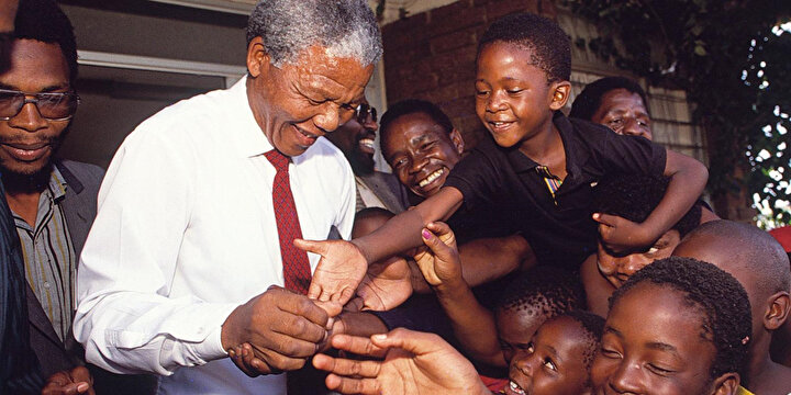 Nelson Rolihlahla Mandela'nın çocuklarla selamlaşırken çekilmiş fotoğrafı.