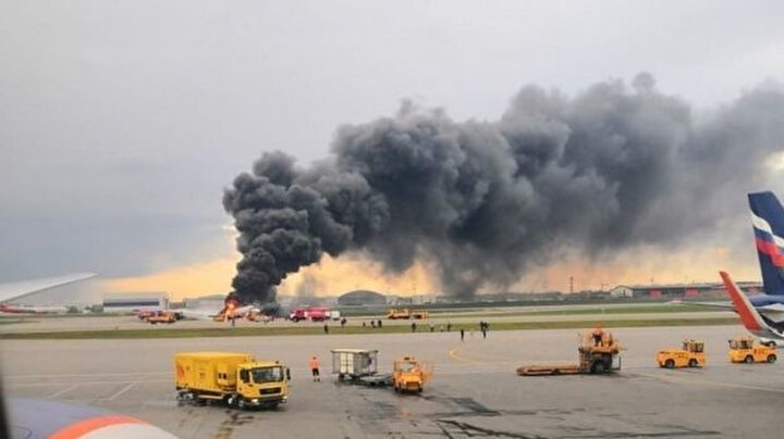 Sheremetyevo havaalanında asfaltta yanan uçaktan siyah duman çıkıyor.