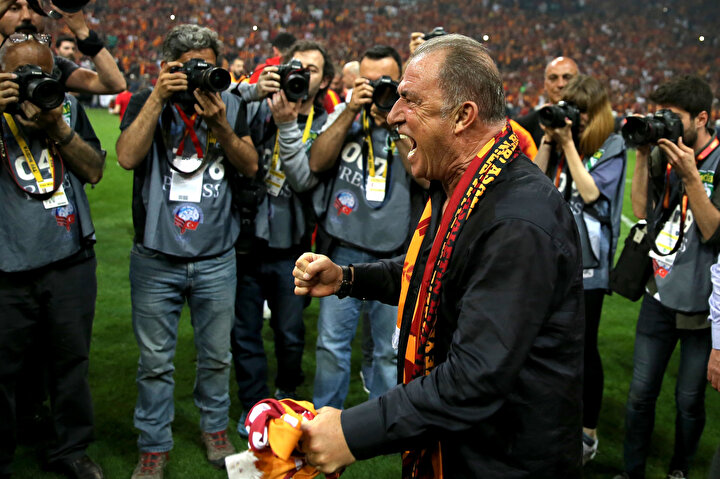 Fatih Terim gazetecilere şampiyonluk pozu veriyor.