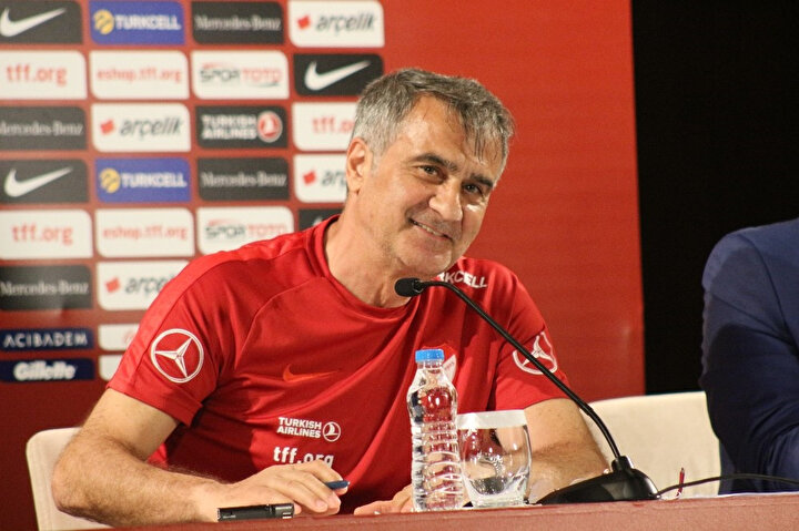 Şenol Güneş bir basın mensubuyla konuşurken gülüyor.