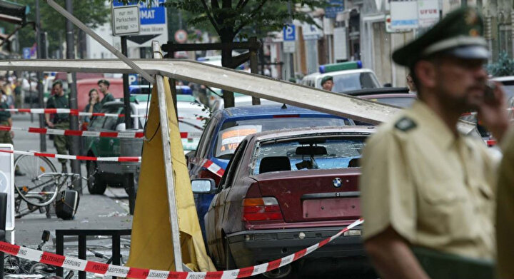 9 Haziran 2004’te NSU üyeleri Uwe Mundlos ve Uwe Böhnhardt tarafından bir bisiklet üzerinde getirilerek, dükkanının önüne konulan 10 santimlik çivilerle dolu bombanın patlatılması sonrasında şans eseri ölen olmamıştı.